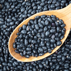 black mexican beans in wooden spoon closeup