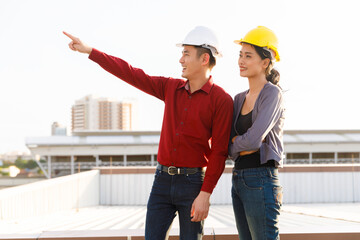 Male and female Asian builders looking away