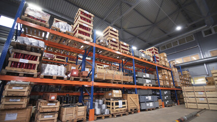 Warehouse with racks and shelves, filled with wooden boxes on pallets. Distribution products. Logistics Business. interior large warehouse with freight stacked high. Written marking on boxes