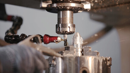 Produces metal detail in factory. Machine tools for metal working. A metal workpiece is machined by an electric machine. Cutting metal modern processing technology. Coolant and lubrication.