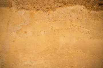 Texture of yellow concrete and stone wall for background