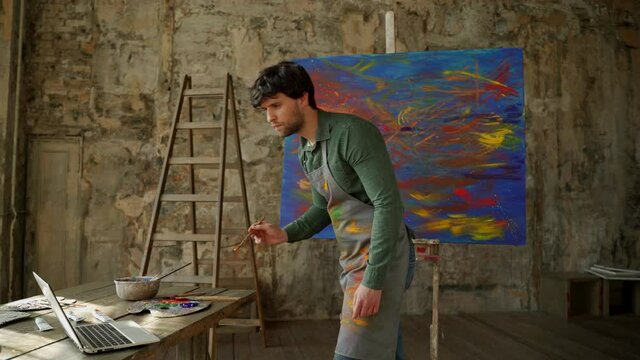 Male artist draws a picture and learns to draw. Man learns to draw online through a laptop