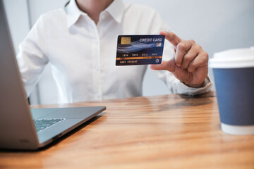 Woman holding credit card and using laptop computer. Online shopping concept.