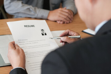 Examiner reading a resume during job interview at office Business and human resources concept