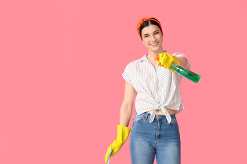 Young woman with cleaning supplies on color background