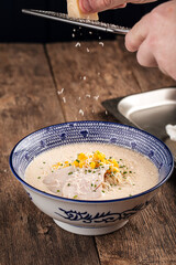 Cooking cheese ramen noodle soup with corn on wooden background