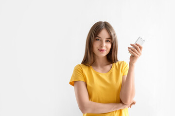Young woman with air conditioner remote control on white background