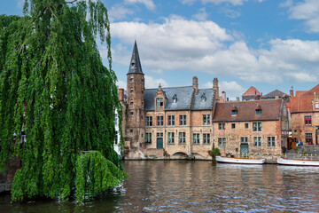 Fototapeta na wymiar City view with historical houses, church, tower and famous canal in Bruges, Belgium.