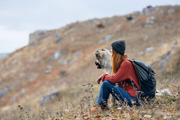 Naklejka na ściany i meble woman in mountains outdoors with dog friendship travel landscape