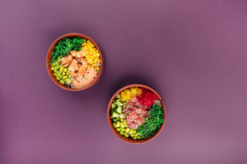 Two bowls of hawaiian poke mix with tuna fish and shrimp on purple background