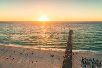 Glenelg beach jetty  with people at sunset viewed from above