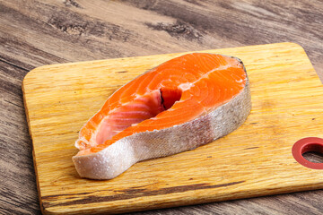 Raw salmon steak over board