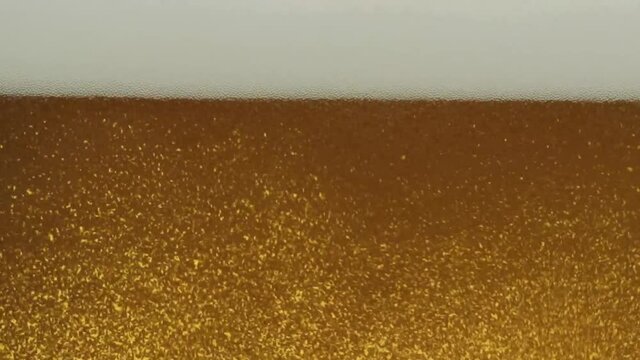 Nahaufnahme beim Einschenken von Bier in ein Glas mit Aufsteigende Blasen