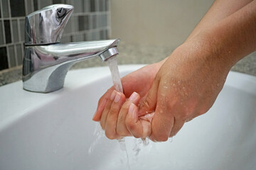 Washing hands with running water under the faucet on sink, Hygiene cleaning hands health care