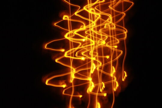 Abstract background light traces in a long-exposure image. Fire waves on a black