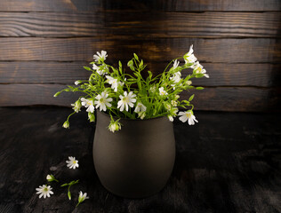 young white wildflowers in an old metal vase