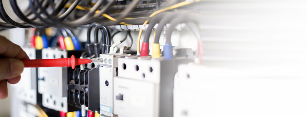 Electrician engineer work tester measuring voltage and current of power electric line in electical...