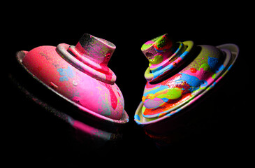 Two paint spray on a dark background in dramatic lighting.