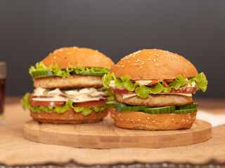 two fresh burgers on a wooden board