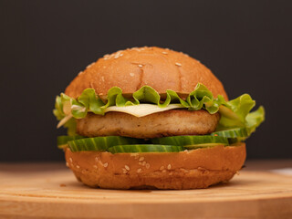 one fresh burger on a wooden board