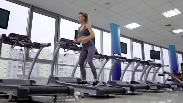 Young sporty Woman On Running Machine In Gym