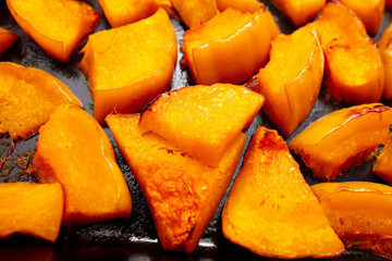 Pieces of pumpkin baked on a baking sheet. Food