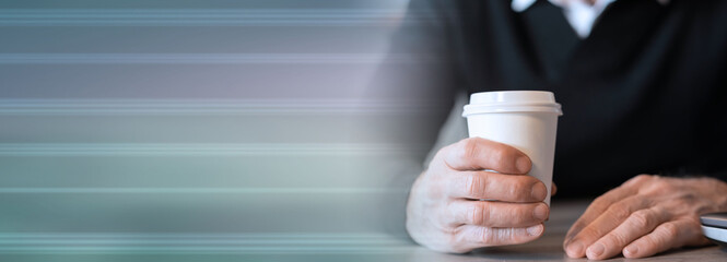 Businessman holding a paper coffee cup; panoramic banner
