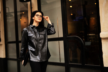 Young smiling woman enjoying outdoors. Beautiful woman using the phone while walking in the morning..