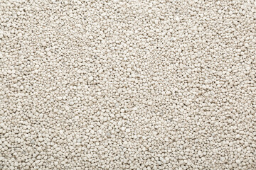 Light gray complex fertiliser granules background. Product for root feeding of vegetables, flowers...