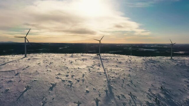 Aerial view of windmills rotating  in heavy wind, top of snowy fells of Lappland