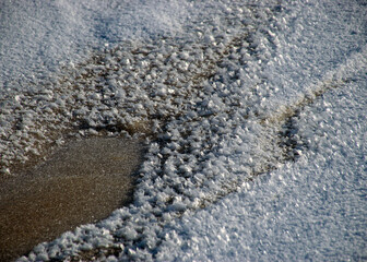 winter landscape by the sea, snowy, interesting ice shapes on the sea shore, dunes covered with a white layer of shining snow