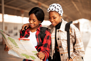 Beautiful girls looking for direction in the city. Young girlfriends travel together..