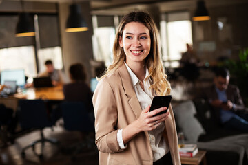 Businesswoman in office. Smiling businesswoman using the phone.