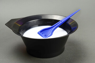 hair dye with a brush in a plastic bowl