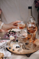 transparent glass with rose wine and snacks close-up. French soft cheese along with blueberries near the glass with a drink. brie cheese and wine