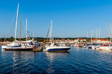 Fototapeta premium Sailing yachts moored on a pier in a harbour on baltic sea in a sunny morning