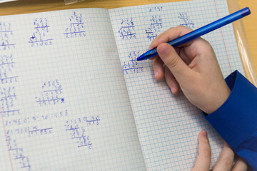 A girl's hand with a ballpoint pen writes in bad handwriting close-up. The student completes the...