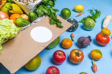 Close-up of fresh vegetables in cardboard box on the table delivered to home, donation box with supplies food for people, vegetables and fruit in cardboard box.