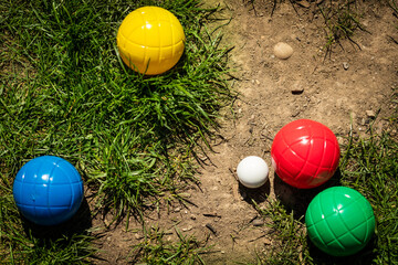 colorful plastic boules or boccia balls are lying on a green meadow