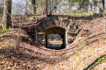 old stone gate with arched vault in the woods