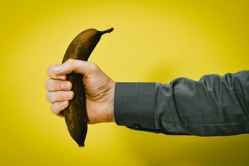 Männerhand hält braune Banane in der Faust