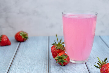 Kissel. Strawberry jelly drink in a glass glass and strawberries on a light background