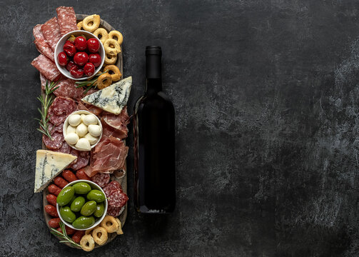 Italian Antipasti Or Charcuterie Board With Wine For A Holiday Entertainment. Assortments Of Meat And Cheese Snacks.