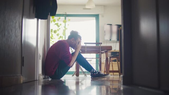 homme, triste, d&eacute;pression, personne, assis, couloir, pleure, position f&oelig;tale, pleurer, bouder, salon, maison, profile, blond, cheveux, long, boucl&eacute;e, fris&eacute;e, pull, rouge, ville, 