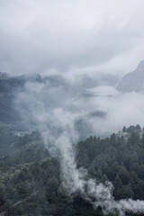 Scenic view of mountain against dramatic sky during foggy weather. Vertical image