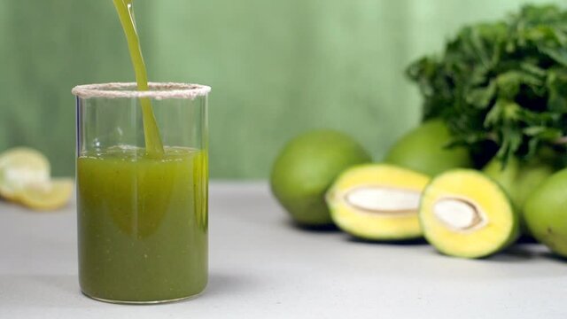 Traditional salted lemonade salted drink Aam Panna with raw mangoes and leaves - Summer drink in India. Closeup shot of raw green mangoes  fresh mint leaves  and citrus yellow lemons on a wooden ta...
