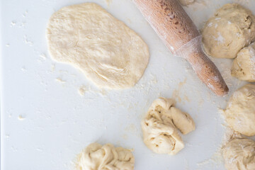 Flat lay angle view of a kitchen desk with flour, dough and roller.