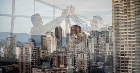 Obraz premium Composition of smiling office colleagues high fiving over cityscape