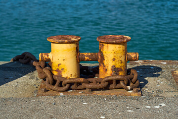 Naklejka premium A double bitt mooring bollard with a heavy chain around it.