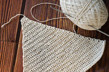 Handmade crocheted with white linen threads on a wooden table.